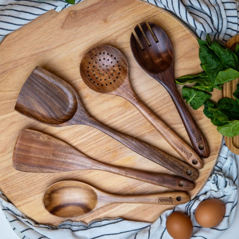 Set of 5 dark wood cooking utensils on round board with eggs and greens